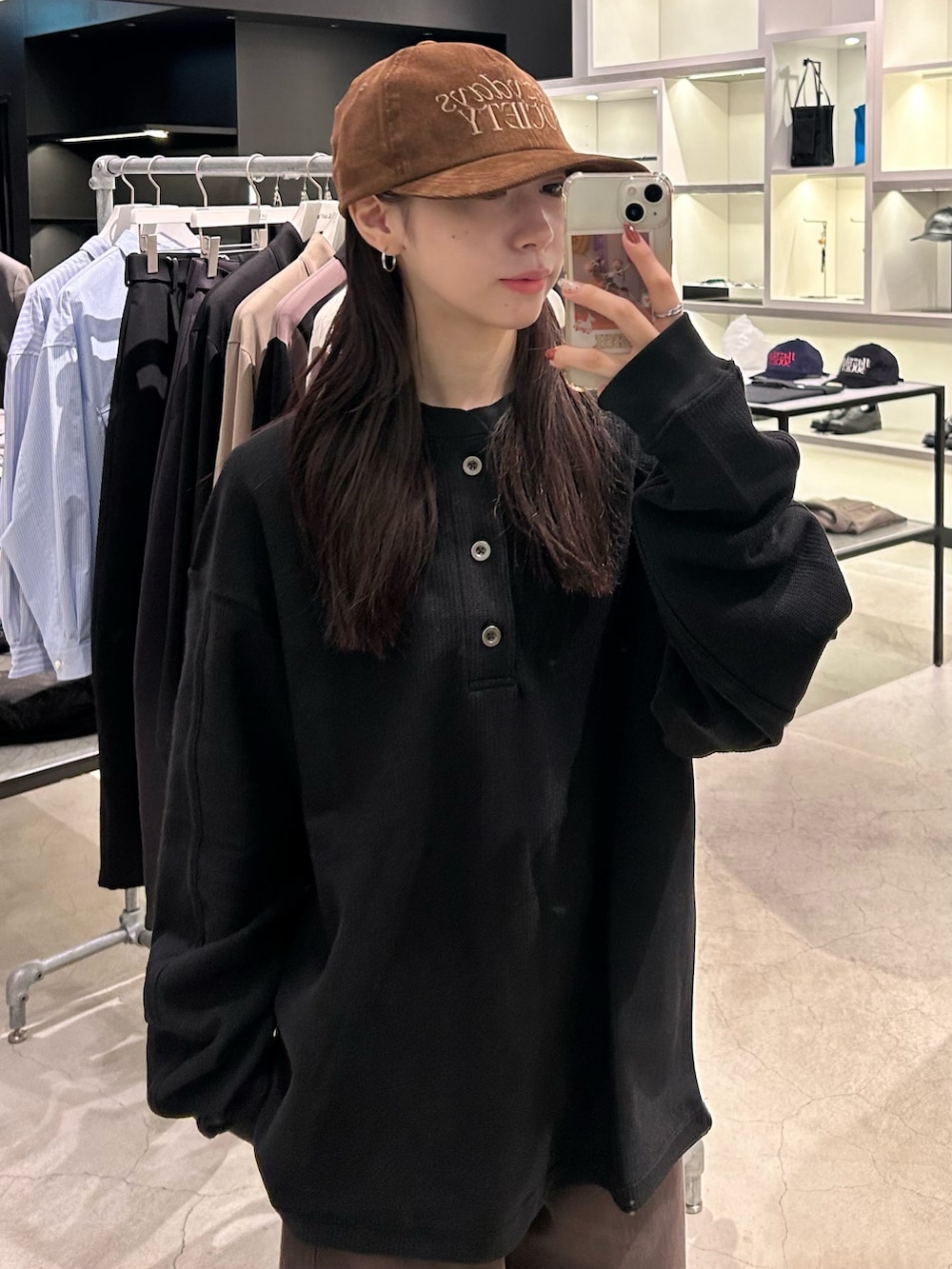 ブラック系のTシャツ/カットソー、ブラウン系のキャップを着用したレディースの秋コーディネートの2枚目の写真