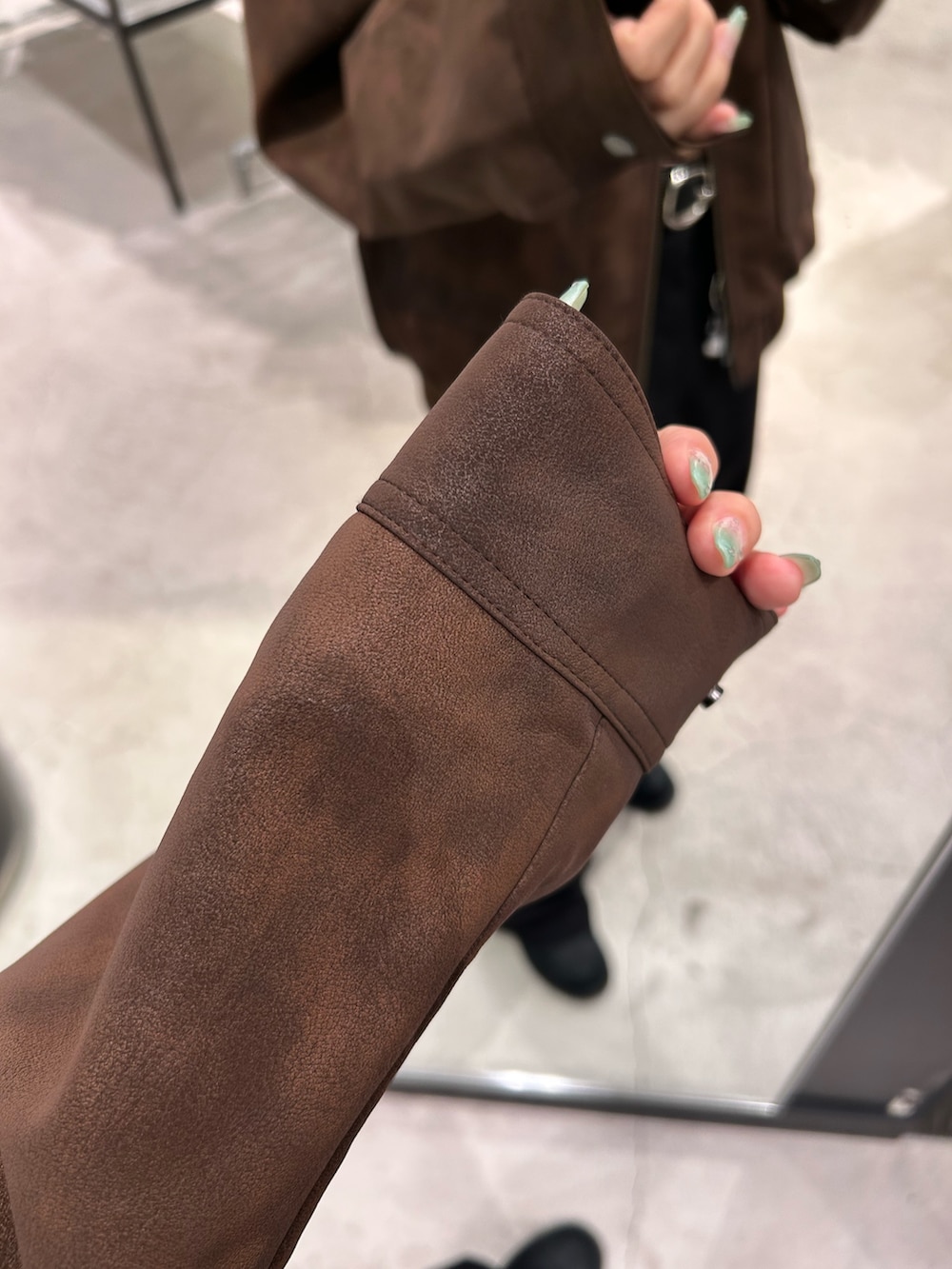 ブラウン系のブルゾン、ブラック系のスラックス、ブラック系のベルトを着用したレディースの秋コーディネートの7枚目の写真