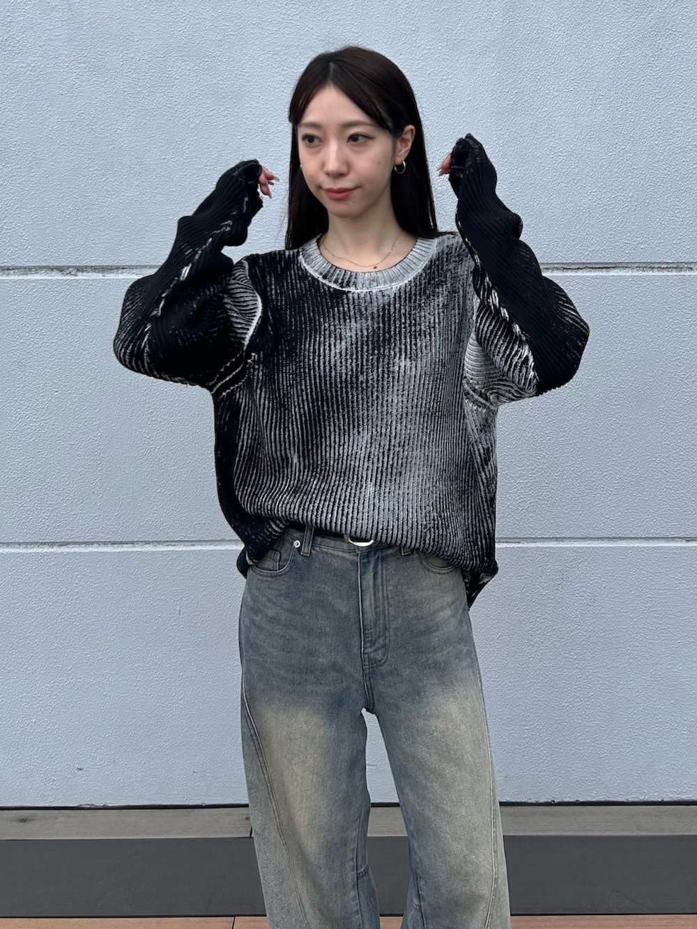 ブルー系のデニムパンツ、ホワイト系のニット/セーター、ブラック系のベルトを着用したレディースの秋コーディネートの6枚目の写真