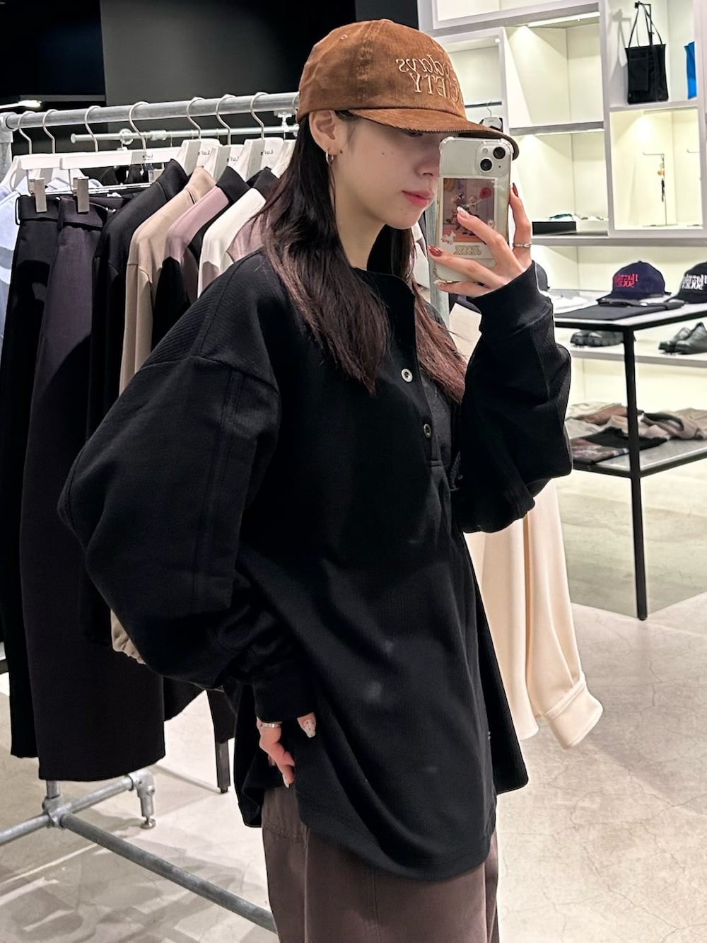 ブラック系のTシャツ/カットソー、ブラウン系のキャップを着用したレディースの秋コーディネートの4枚目の写真