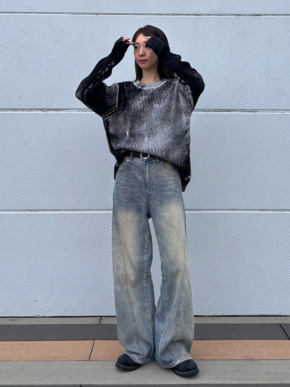 ブルー系のデニムパンツ、ホワイト系のニット/セーター、ブラック系のベルトを着用したレディースの秋コーディネートの3枚目の写真