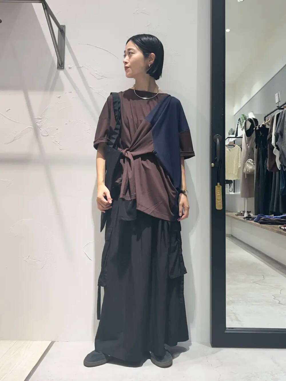 ブラウン系のTシャツ/カットソー、ブラック系のスカート、ブラック系のトートバッグを着用したレディースの秋コーディネートの2枚目の写真