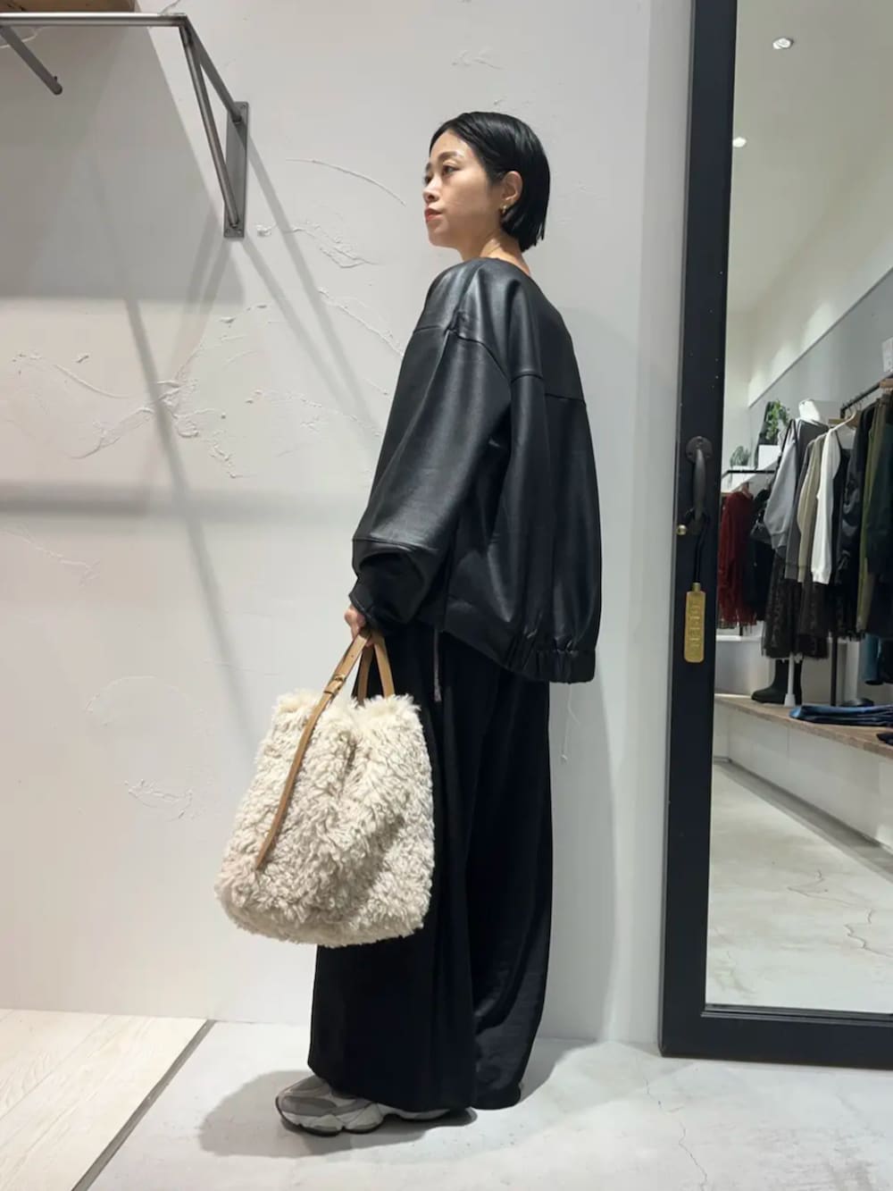 ブラウン系のニット/セーター、ブラック系のその他パンツ、ブラック系のブルゾンを着用したレディースの秋コーディネートの2枚目の写真