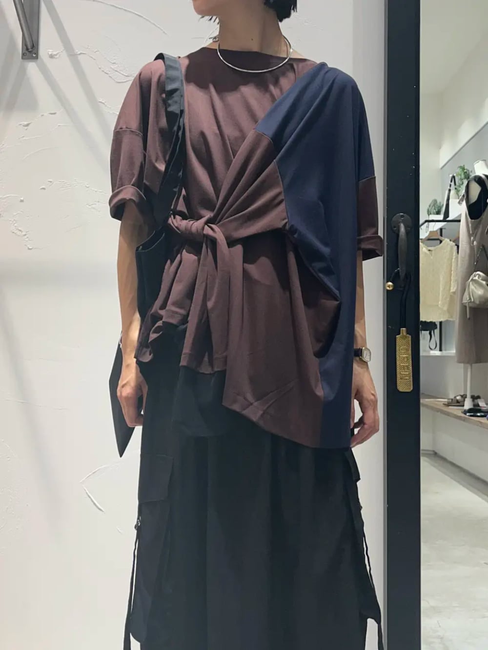 ブラウン系のTシャツ/カットソー、ブラック系のスカート、ブラック系のトートバッグを着用したレディースの秋コーディネートの3枚目の写真