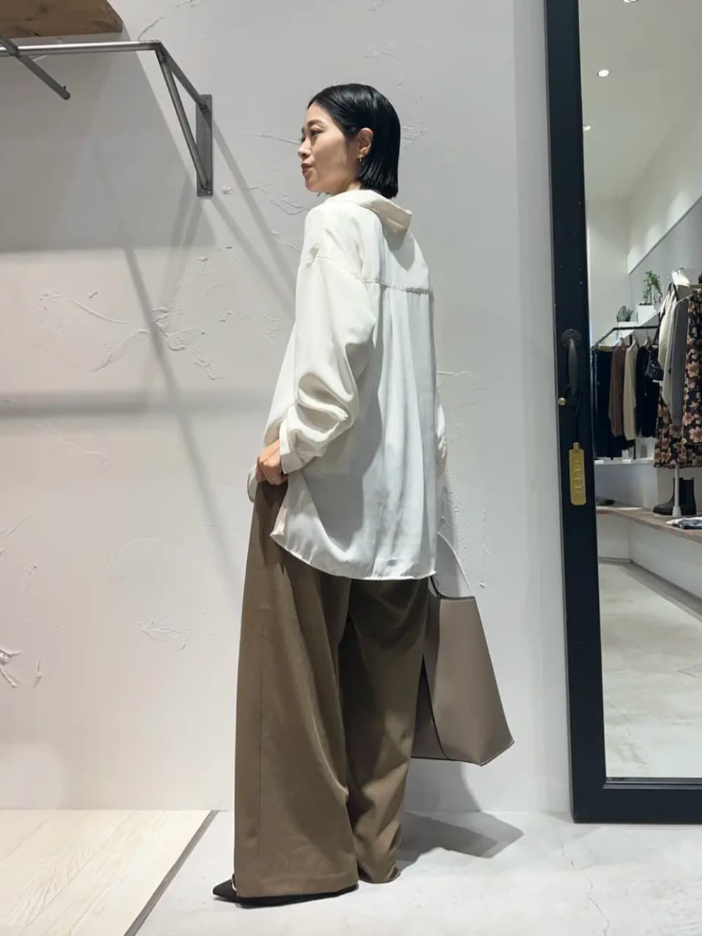 ホワイト系のシャツ/ブラウス、ブラウン系のパンプス、ベージュ系のその他パンツを着用したレディースの秋コーディネートの2枚目の写真