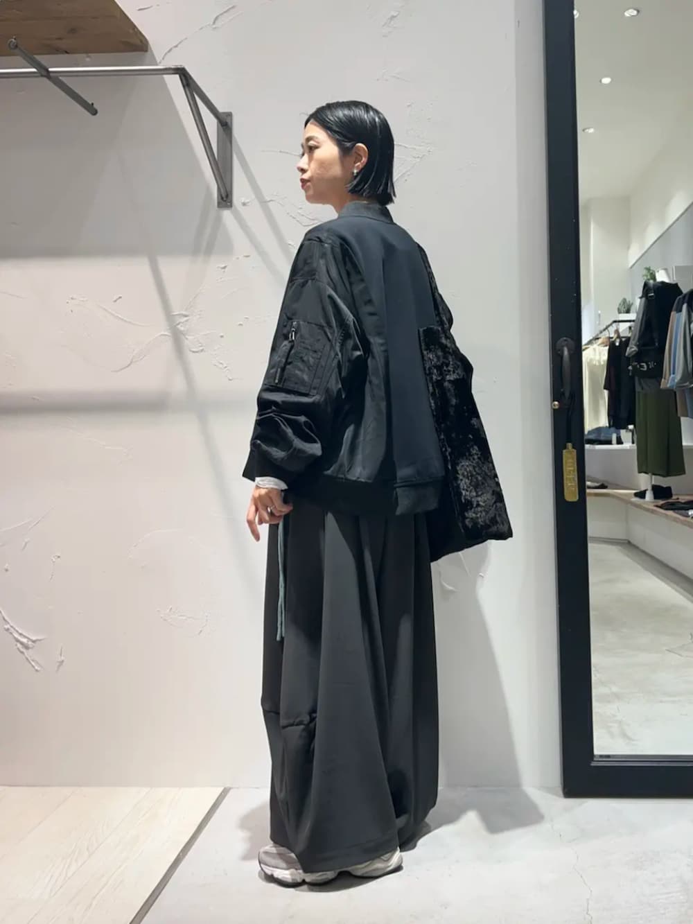 ブラック系のブルゾン、グリーン系のニット/セーター、ホワイト系のTシャツ/カットソーを着用したレディースの秋コーディネートの2枚目の写真