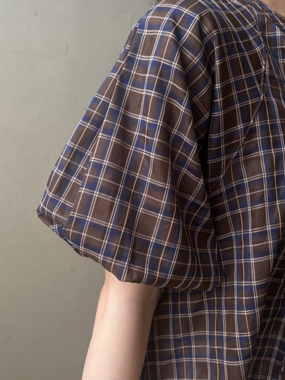 ブラウン系のシャツ/ブラウス、グレー系のスカート、ブラック系のショルダーバッグを着用したレディースの春コーディネートの6枚目の写真