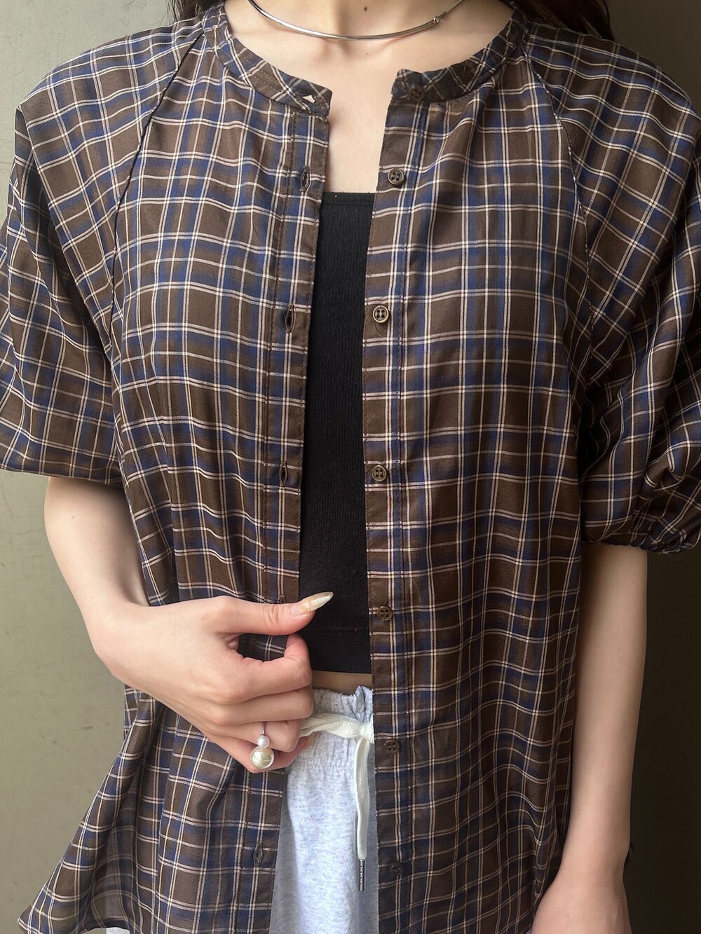 ブラウン系のシャツ/ブラウス、グレー系のスカート、ブラック系のショルダーバッグを着用したレディースの春コーディネートの5枚目の写真
