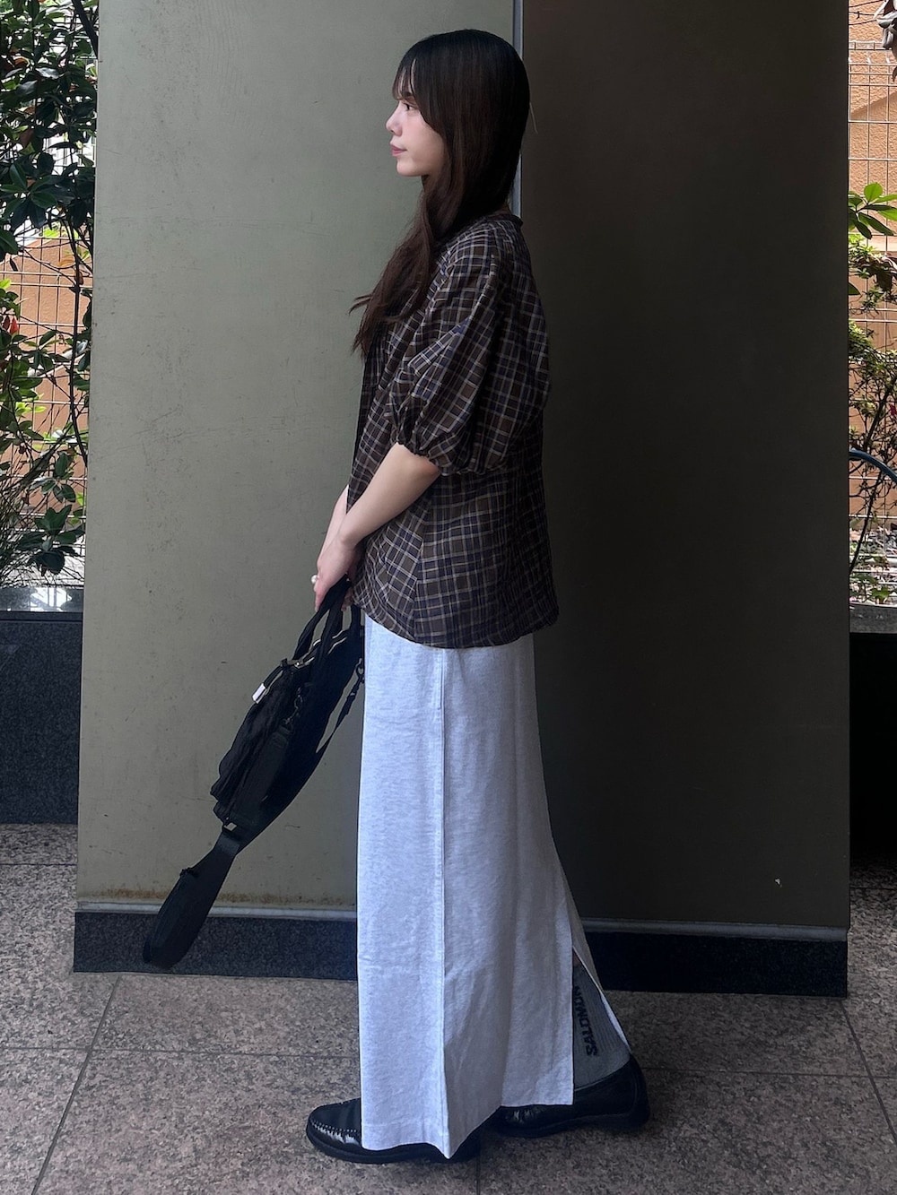 ブラウン系のシャツ/ブラウス、グレー系のスカート、ブラック系のショルダーバッグを着用したレディースの春コーディネートの3枚目の写真