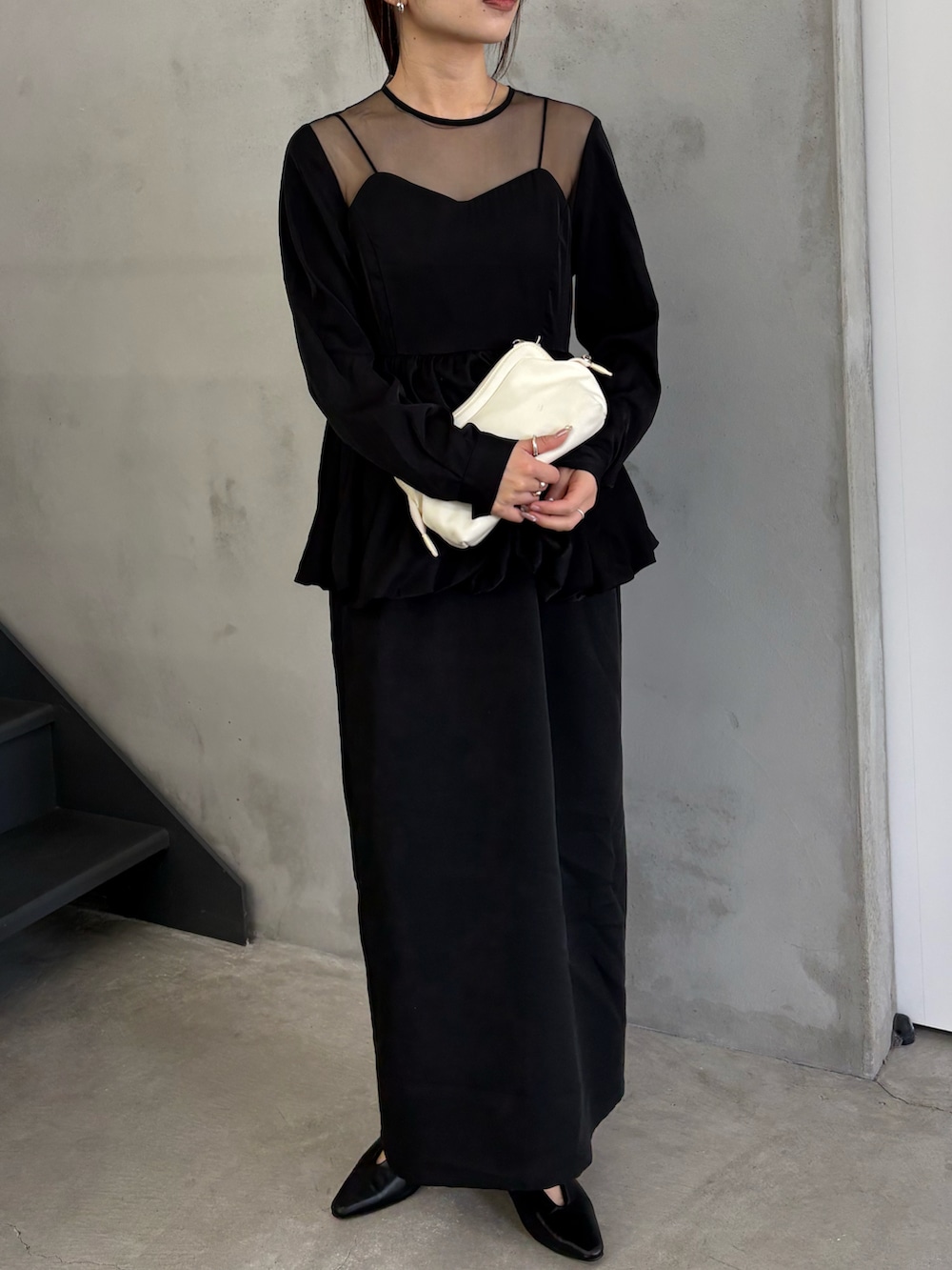 ブラック系のキャミソール、ブラック系のドレス、ホワイト系のショルダーバッグを着用したレディースの秋コーディネートの2枚目の写真