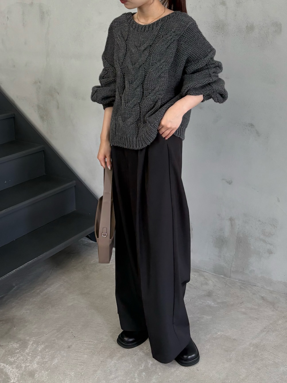 ブラウン系のショルダーバッグ、ブラック系のスラックス、ブラック系のスリッポンを着用したレディースの秋コーディネートの3枚目の写真