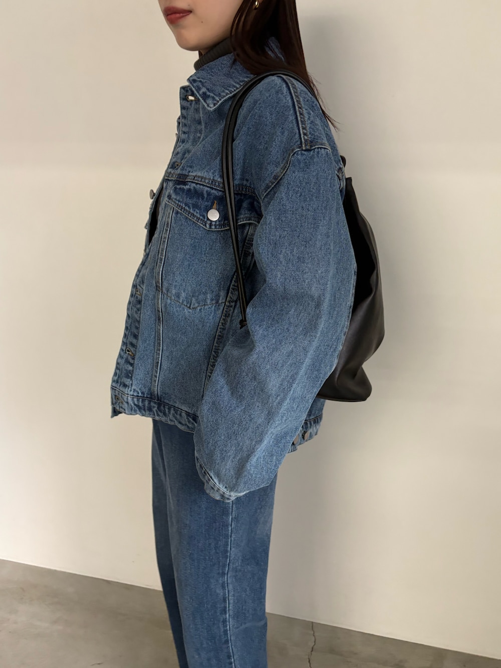 ブルー系のデニムジャケット、ブルー系のデニムパンツ、ブラック系のブーツを着用したレディースの冬コーディネートの5枚目の写真