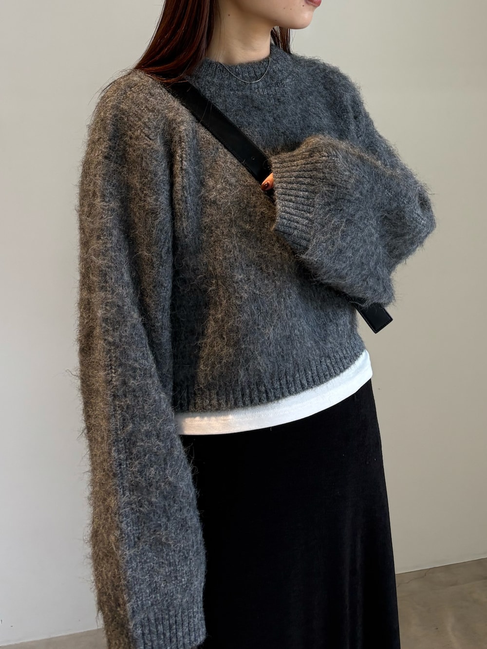 ブラック系のスカート、ブラック系のスリッポン、グレー系のニット/セーターを着用したレディースの秋コーディネートの4枚目の写真