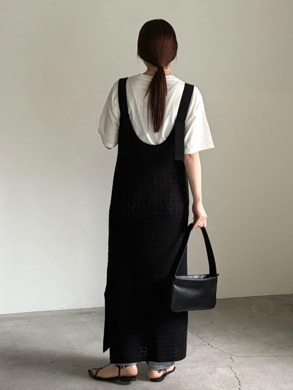 ホワイト系のTシャツ/カットソー、ブラック系のワンピース、ブルー系のデニムパンツを着用したレディースの春コーディネートの5枚目の写真