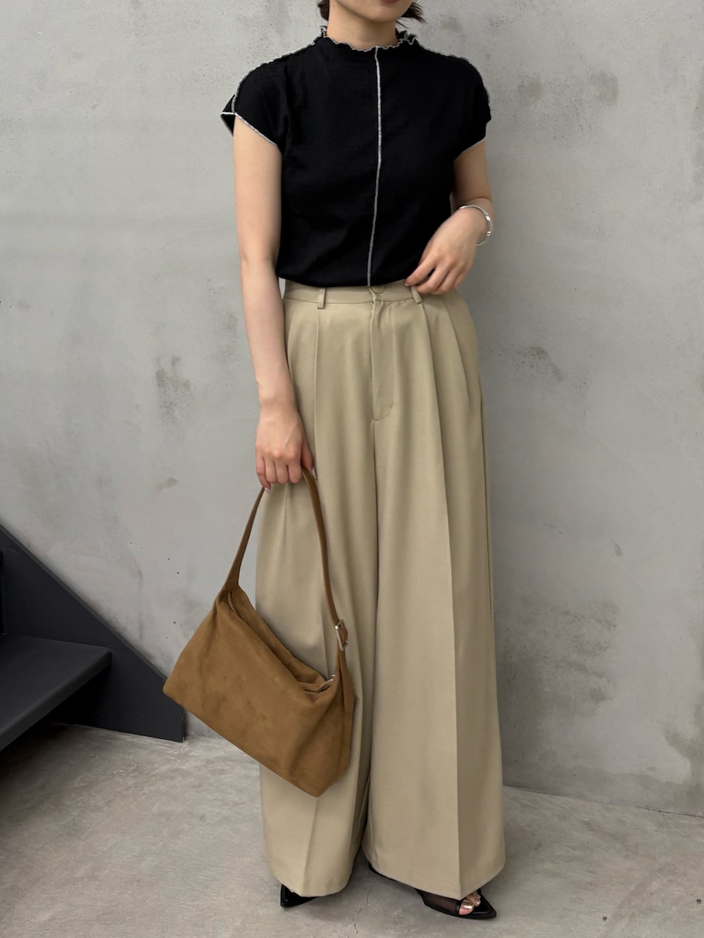 ブラック系のTシャツ/カットソー、ベージュ系のスラックス、ブラック系のサンダルを着用したレディースの夏コーディネートの3枚目の写真