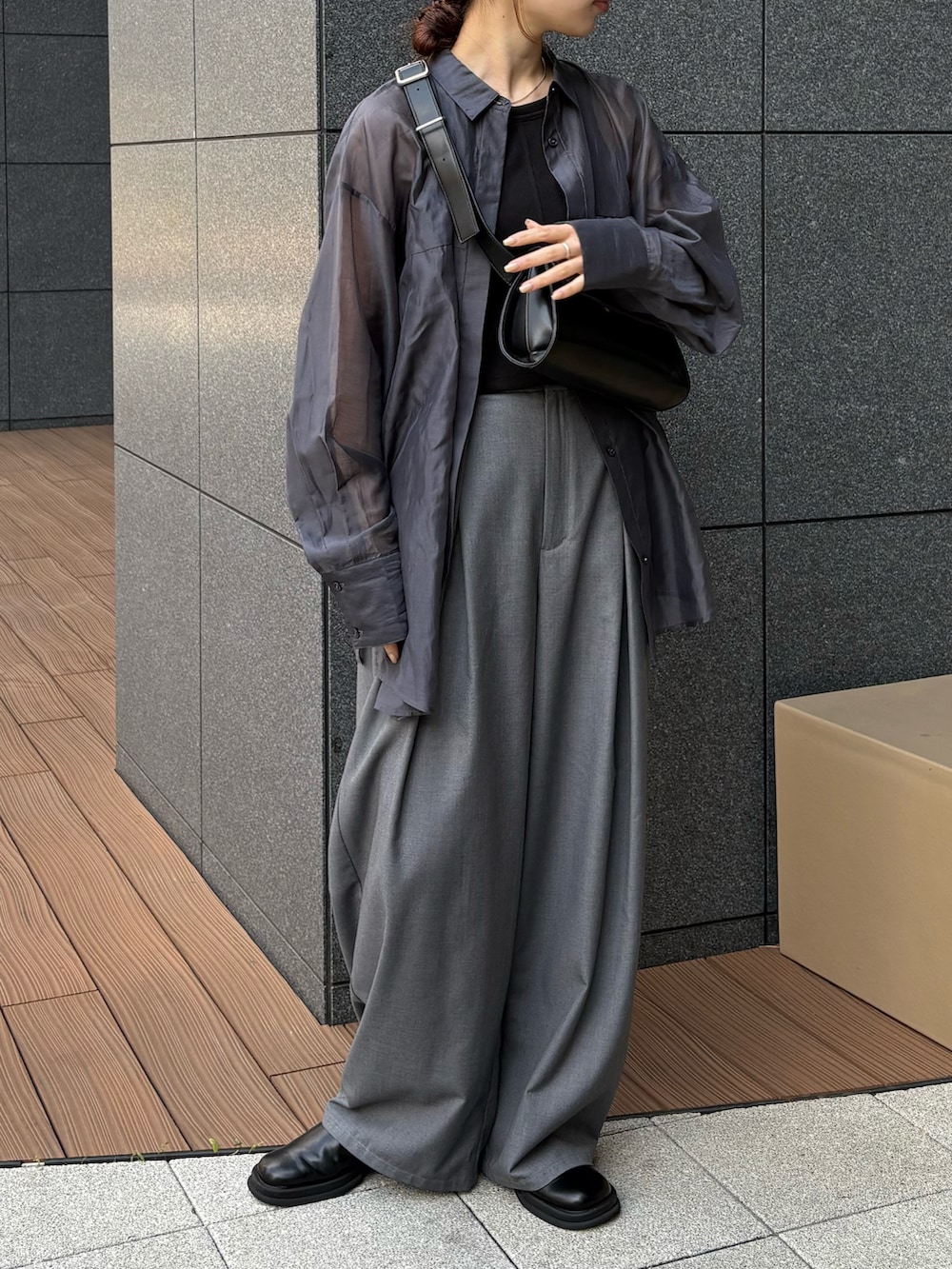 ブラック系のショルダーバッグ、ブルー系のシャツ/ブラウス、ブラック系のワンピースを着用したレディースの春コーディネートの2枚目の写真