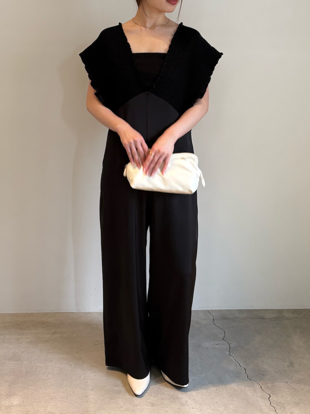 ホワイト系のショルダーバッグ、ブラック系のキャミソール、ブラック系のパンツドレスを着用したレディースの春コーディネートの2枚目の写真