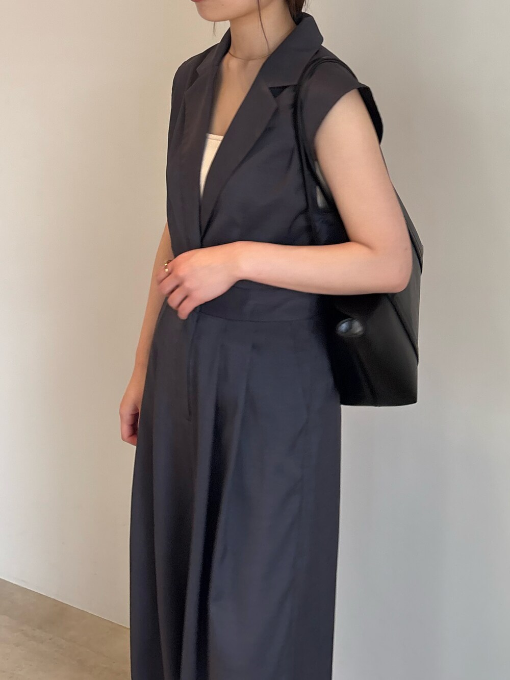 ブラック系のショルダーバッグ、グレー系のパンツドレスを着用したレディースの春コーディネートの4枚目の写真