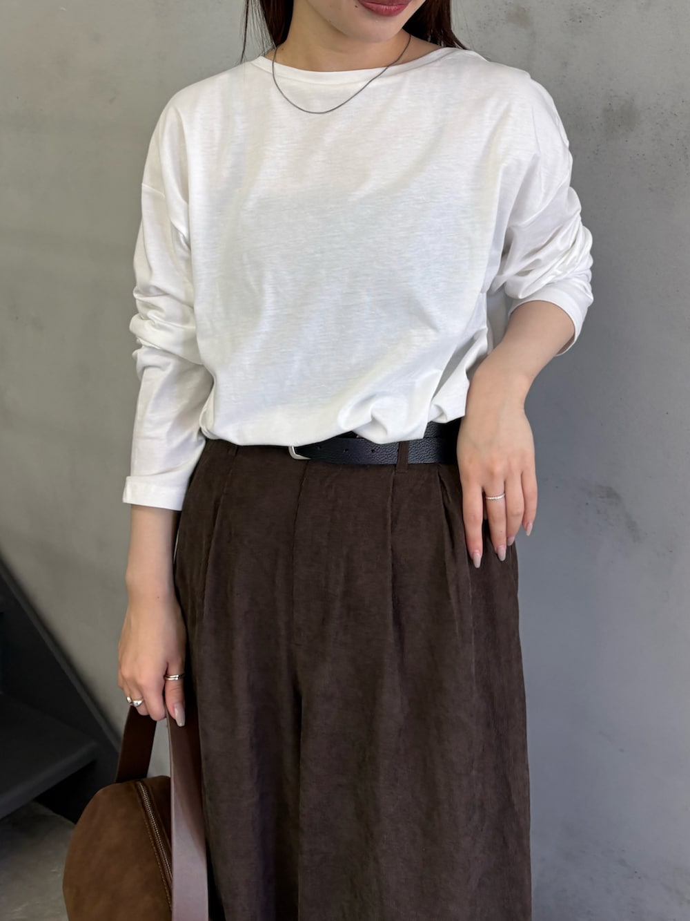 ホワイト系のTシャツ/カットソー、ブラウン系のスラックス、ブラウン系のハンドバッグを着用したレディースの夏コーディネートの5枚目の写真