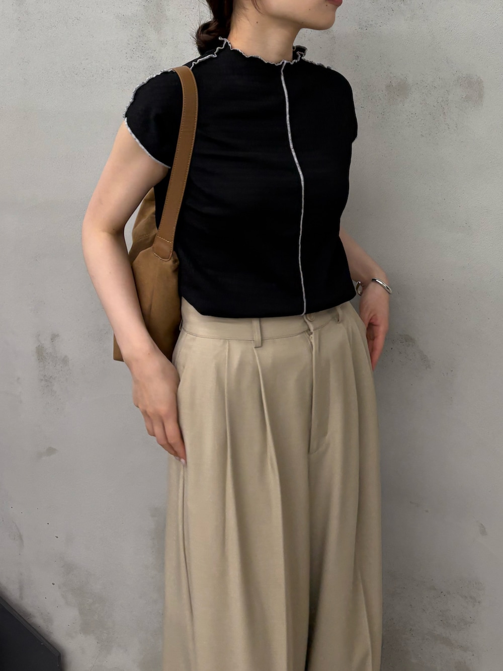 ブラック系のTシャツ/カットソー、ベージュ系のスラックス、ブラック系のサンダルを着用したレディースの夏コーディネートの5枚目の写真