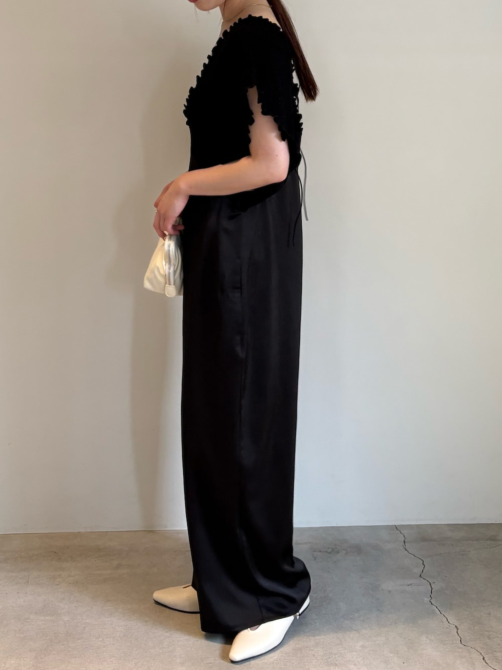 ホワイト系のショルダーバッグ、ブラック系のキャミソール、ブラック系のパンツドレスを着用したレディースの春コーディネートの3枚目の写真