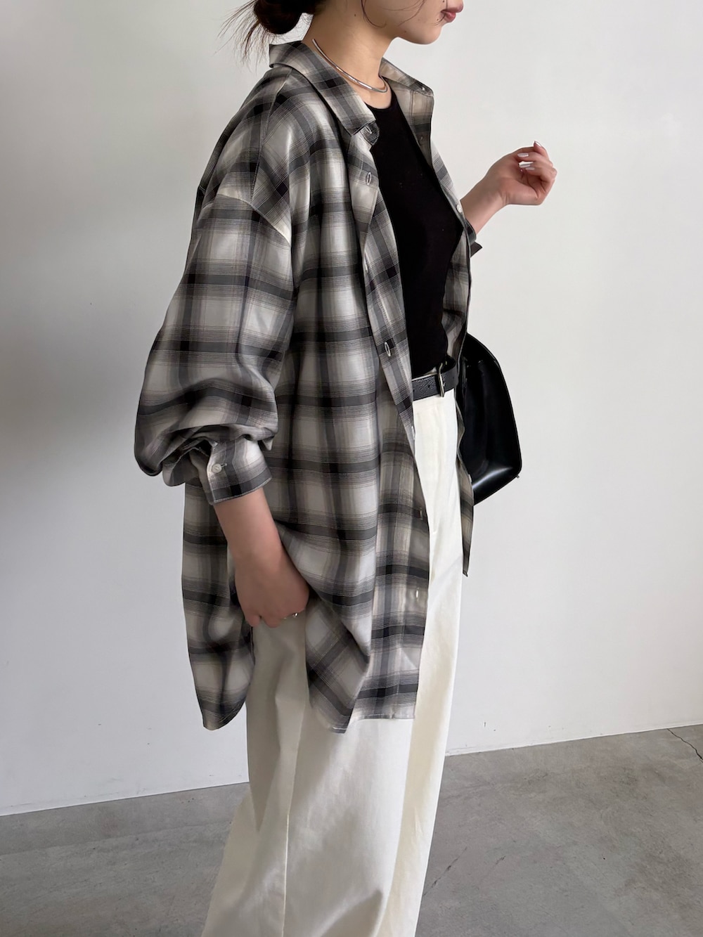 ブラック系のシャツ/ブラウス、ブラック系のボストンバッグ、ブラック系のスリッポンを着用したレディースの冬コーディネートの3枚目の写真