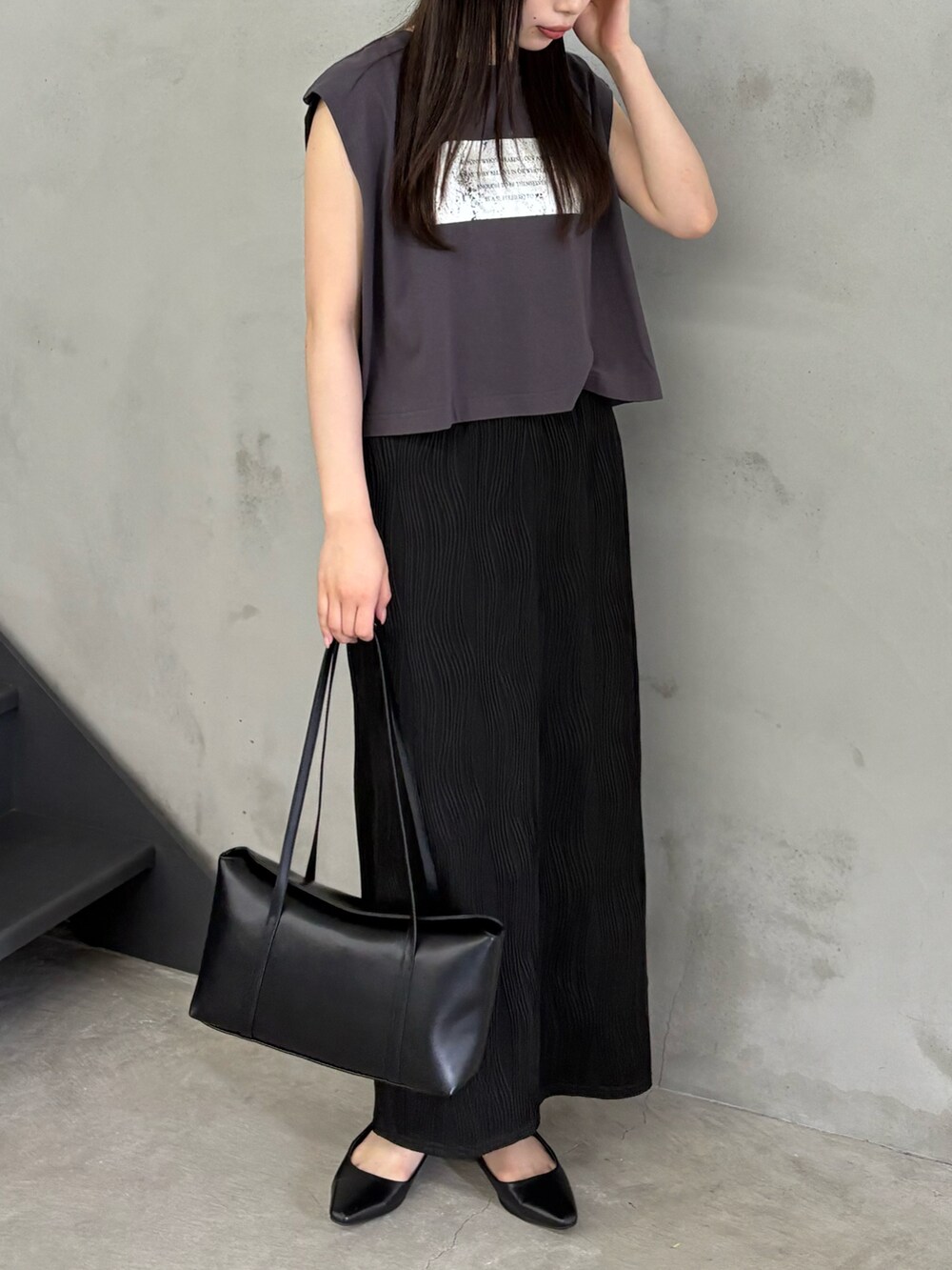 ブラック系のTシャツ/カットソー、ブラック系のスカート、ブラック系のショルダーバッグを着用したレディースの春コーディネートの2枚目の写真