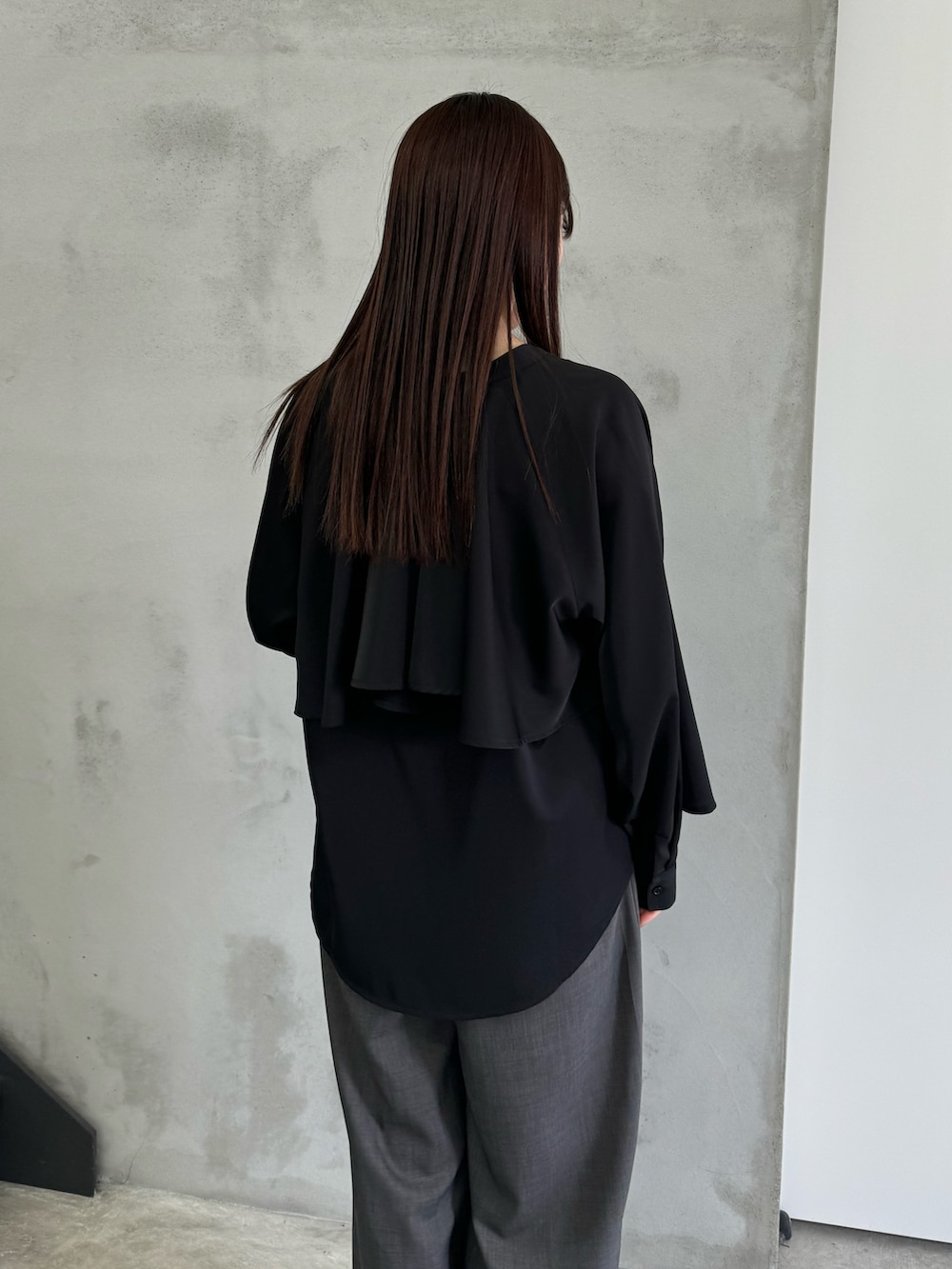 ブラック系のシャツ/ブラウス、ブラック系のキャミソール、グレー系のスラックスを着用したレディースの冬コーディネートの4枚目の写真