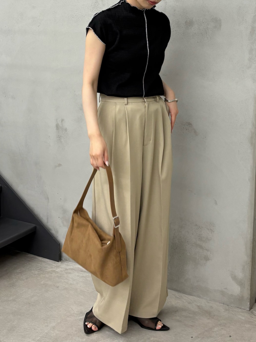 ブラック系のTシャツ/カットソー、ベージュ系のスラックス、ブラック系のサンダルを着用したレディースの夏コーディネートの2枚目の写真