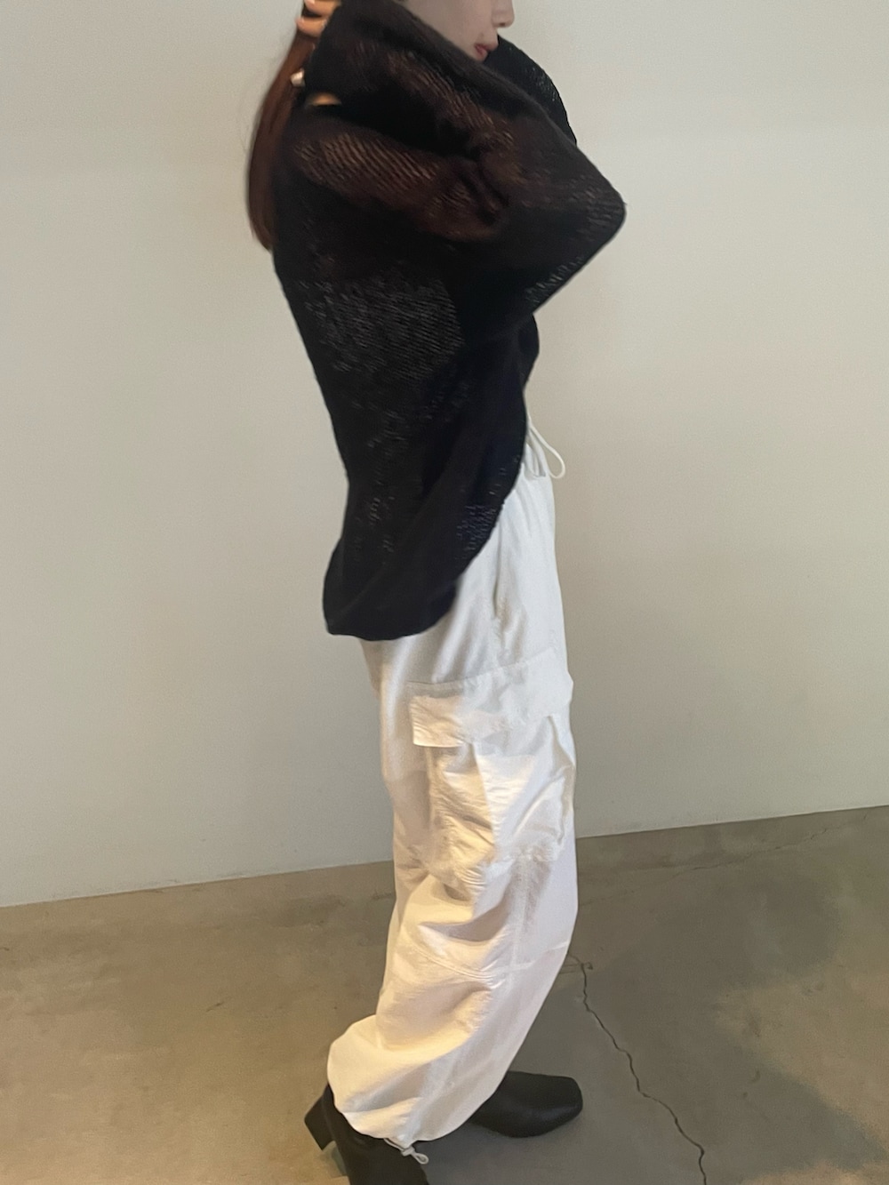 ブラック系のニット/セーター、ホワイト系のカーゴパンツを着用したレディースの夏コーディネートの4枚目の写真