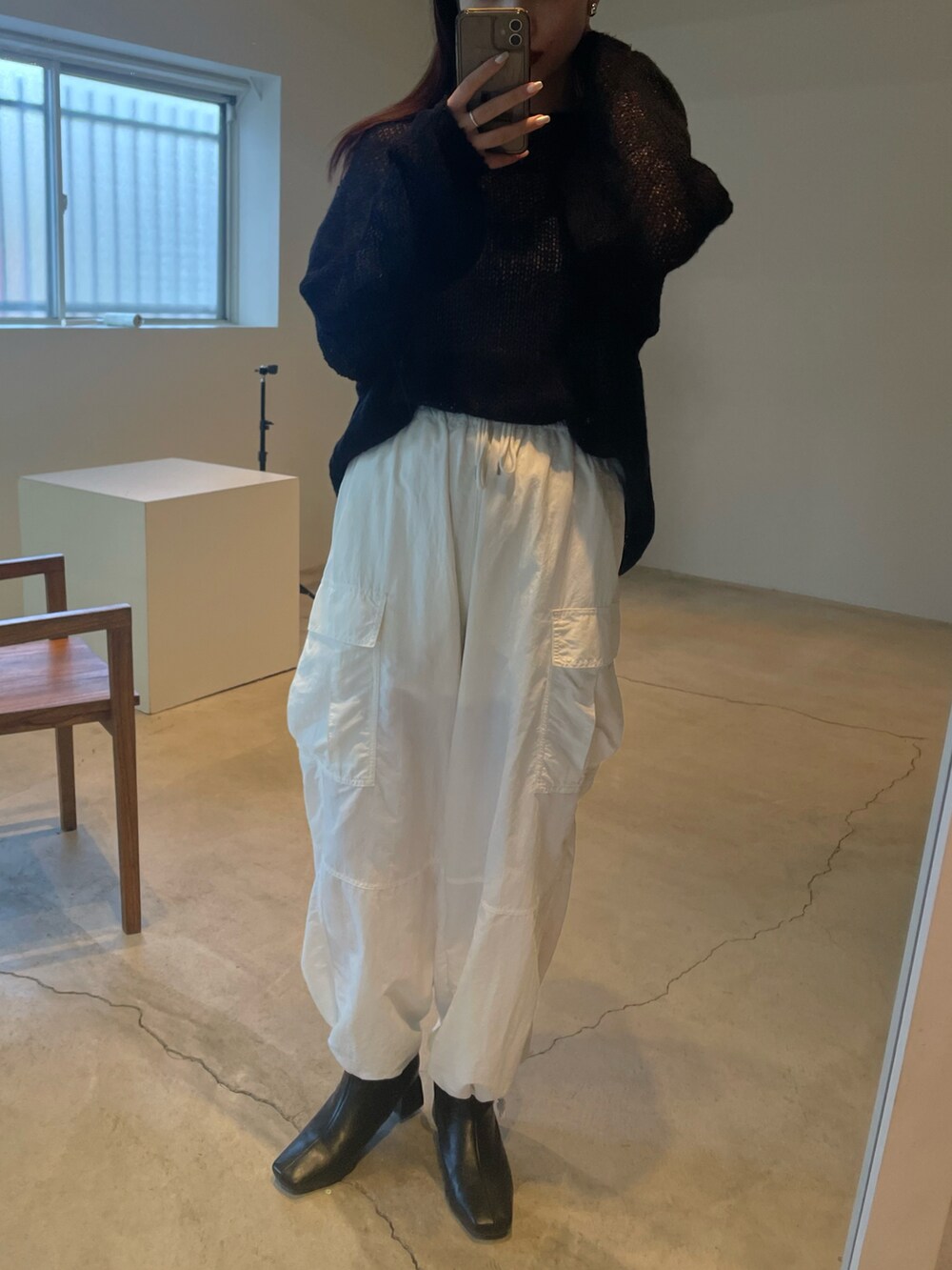 ブラック系のニット/セーター、ホワイト系のカーゴパンツを着用したレディースの夏コーディネートの5枚目の写真