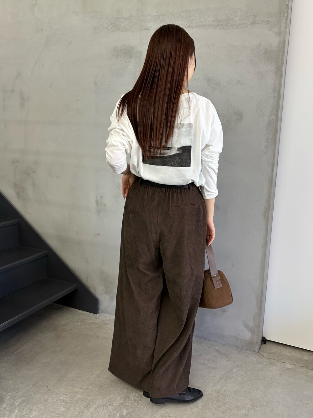 ホワイト系のTシャツ/カットソー、ブラウン系のスラックス、ブラウン系のハンドバッグを着用したレディースの夏コーディネートの4枚目の写真