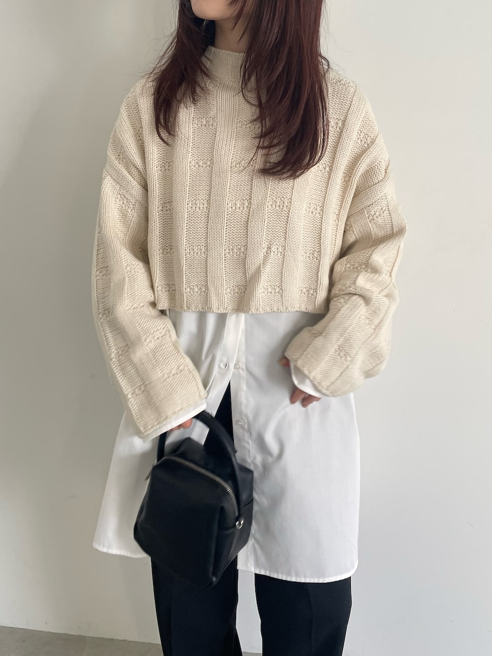 ホワイト系のニット/セーター、ホワイト系のシャツ/ブラウス、ブラック系のスラックスを着用したレディースの冬コーディネートの4枚目の写真