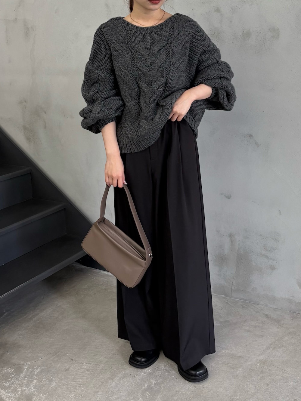 ブラウン系のショルダーバッグ、ブラック系のスラックス、ブラック系のスリッポンを着用したレディースの秋コーディネートの2枚目の写真