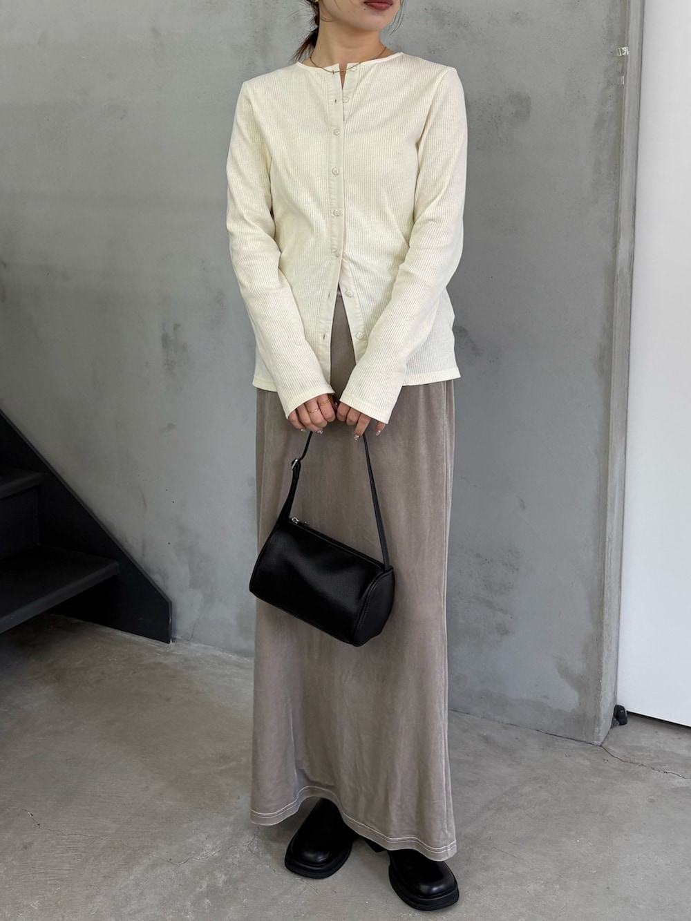 ホワイト系のTシャツ/カットソー、グレー系のスカート、ブラック系のスリッポンを着用したレディースの冬コーディネートの2枚目の写真