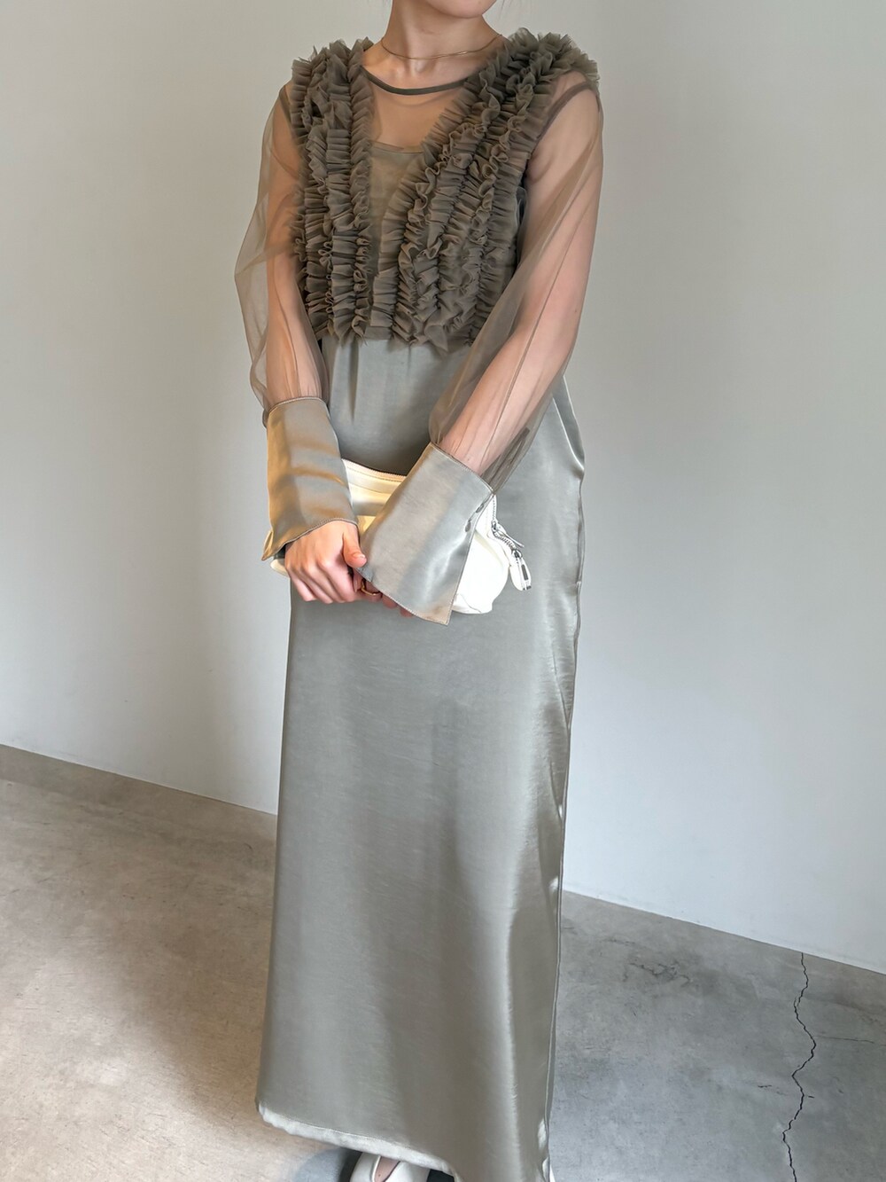 ブラック系のキャミソール、ホワイト系のショルダーバッグ、ベージュ系のドレスを着用したレディースの春コーディネートの5枚目の写真