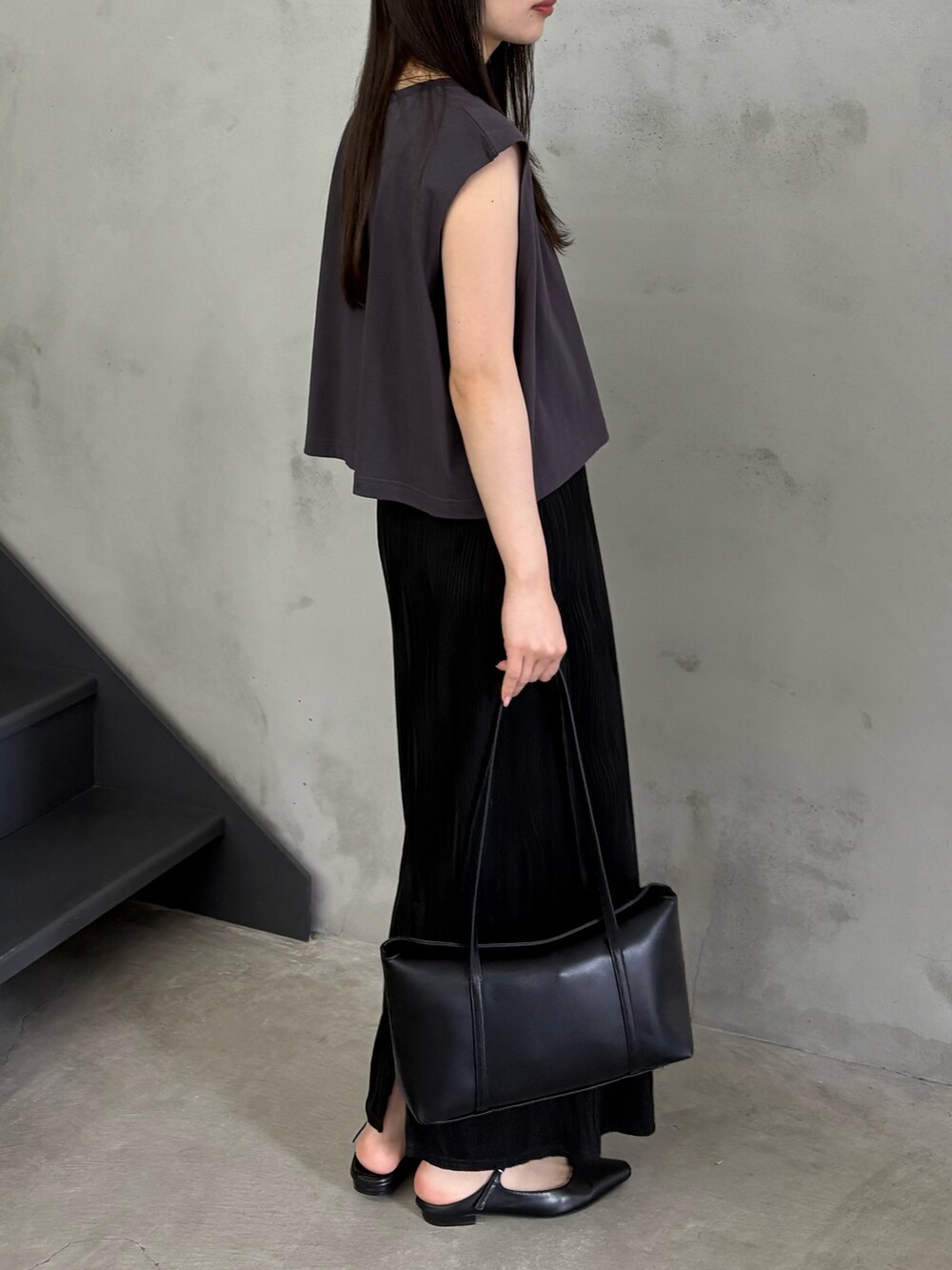 ブラック系のTシャツ/カットソー、ブラック系のスカート、ブラック系のショルダーバッグを着用したレディースの春コーディネートの3枚目の写真