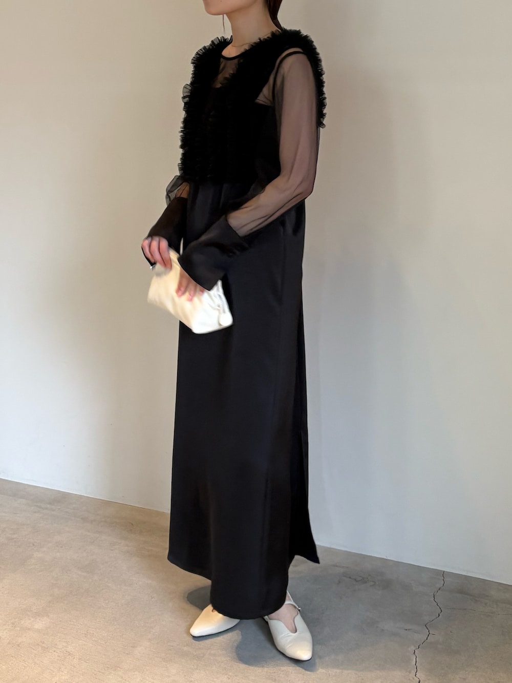 ホワイト系のショルダーバッグ、ブラック系のドレスを着用したレディースの春コーディネートの2枚目の写真