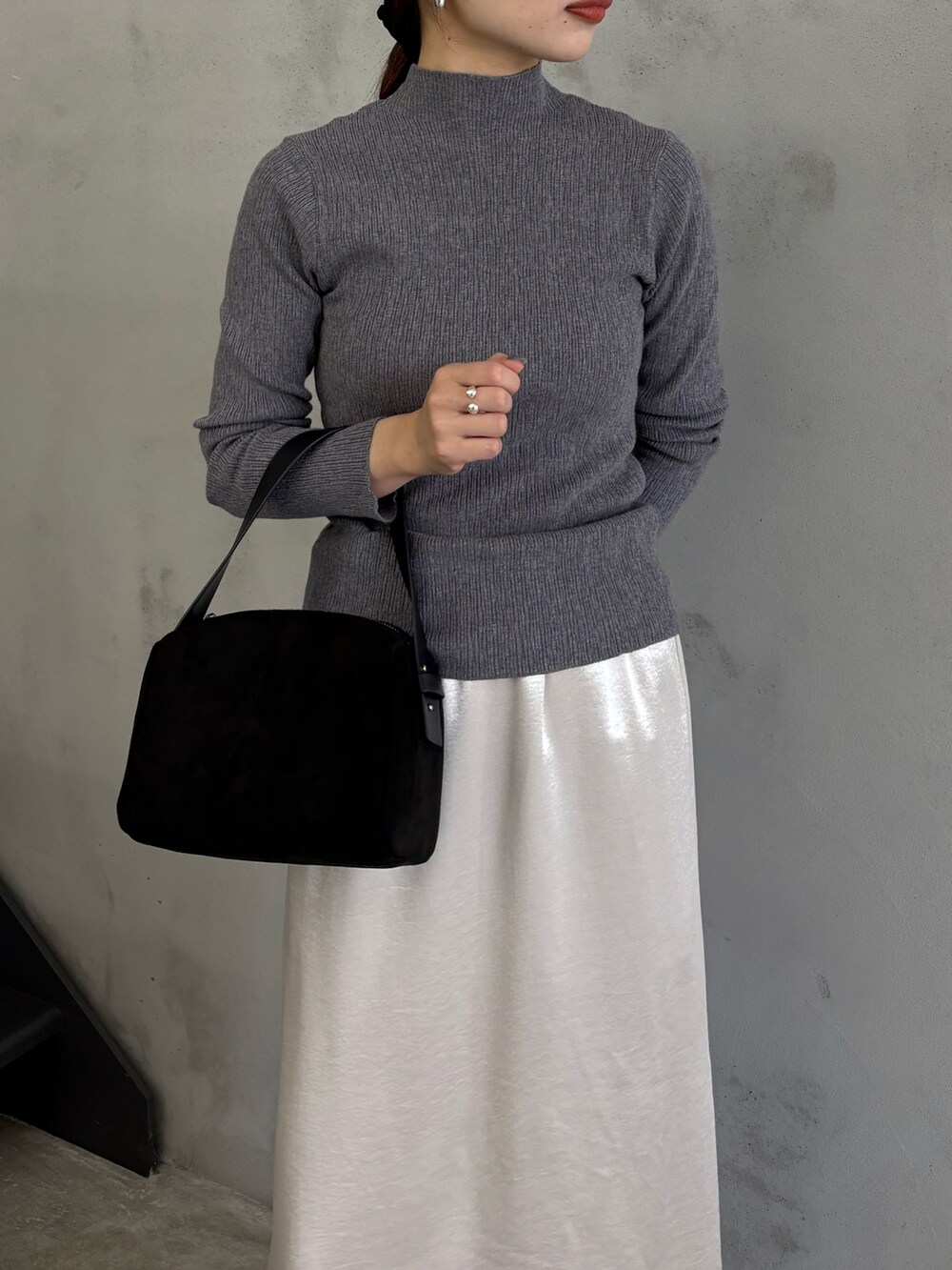 グレー系のTシャツ/カットソー、ブラック系のハンドバッグ、ブラック系のブーツを着用したレディースの秋コーディネートの3枚目の写真