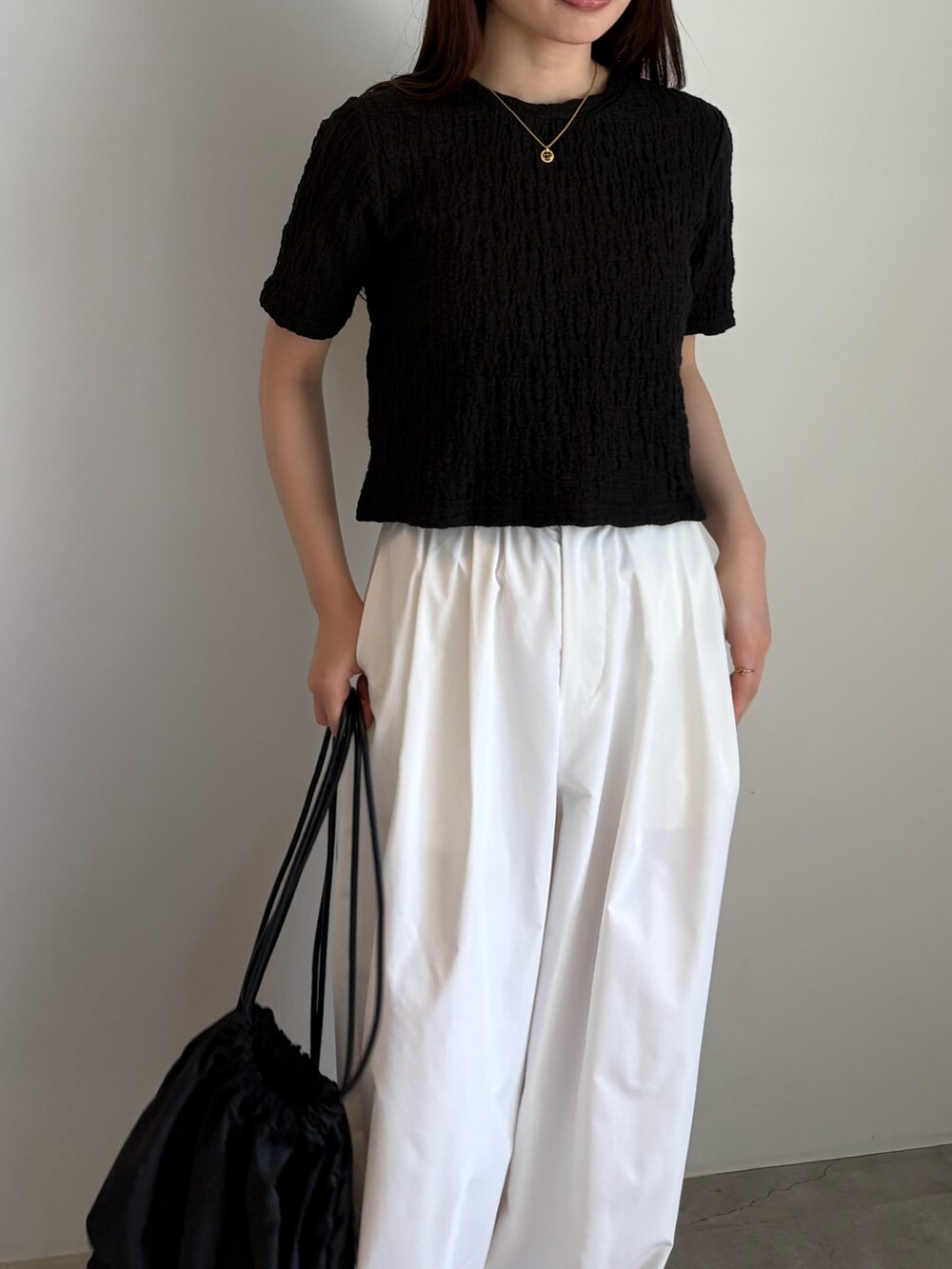 ブラック系のTシャツ/カットソー、ホワイト系のその他パンツ、ブラック系のバックパック/リュックを着用したレディースの夏コーディネートの2枚目の写真