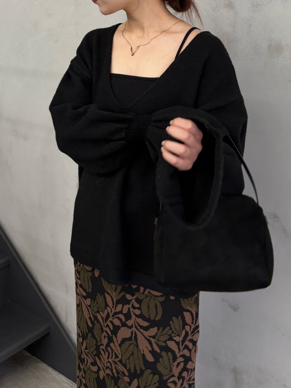 ブラック系のキャミソール、ブラック系のハンドバッグ、ブラウン系のスカートを着用したレディースの冬コーディネートの4枚目の写真