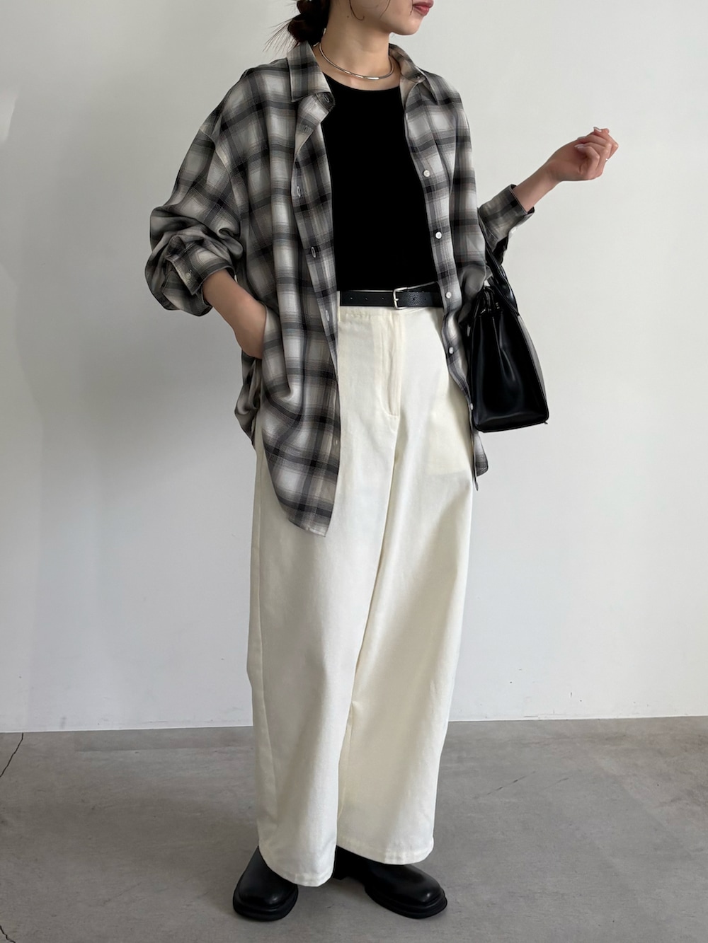 ブラック系のシャツ/ブラウス、ブラック系のボストンバッグ、ブラック系のスリッポンを着用したレディースの冬コーディネートの2枚目の写真