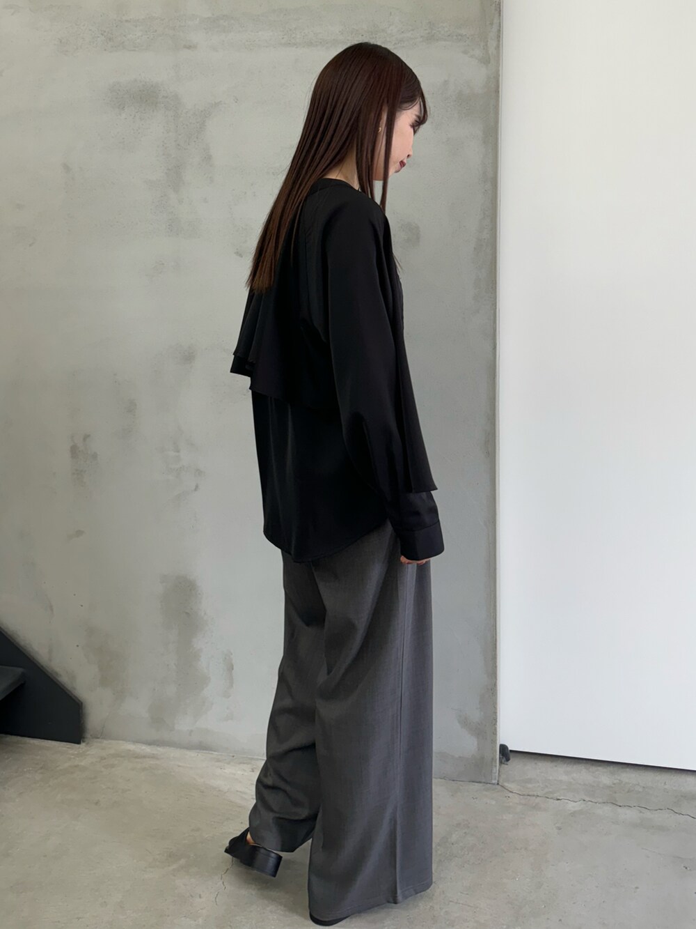 ブラック系のシャツ/ブラウス、ブラック系のキャミソール、グレー系のスラックスを着用したレディースの冬コーディネートの3枚目の写真