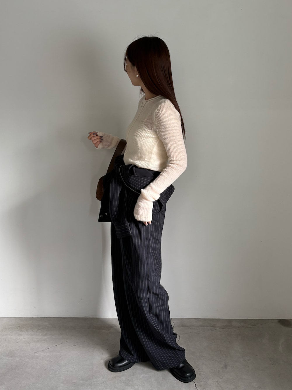 ホワイト系のキャミソール、ブラック系のスリッポン、ホワイト系のニット/セーターを着用したレディースの夏コーディネートの2枚目の写真