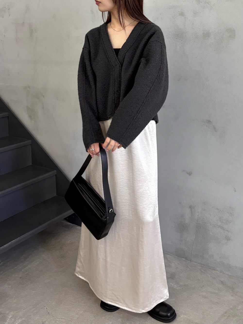 グレー系のカーディガン/ボレロ、ブラック系のキャミソール、ブラック系のショルダーバッグを着用したレディースの秋コーディネートの2枚目の写真