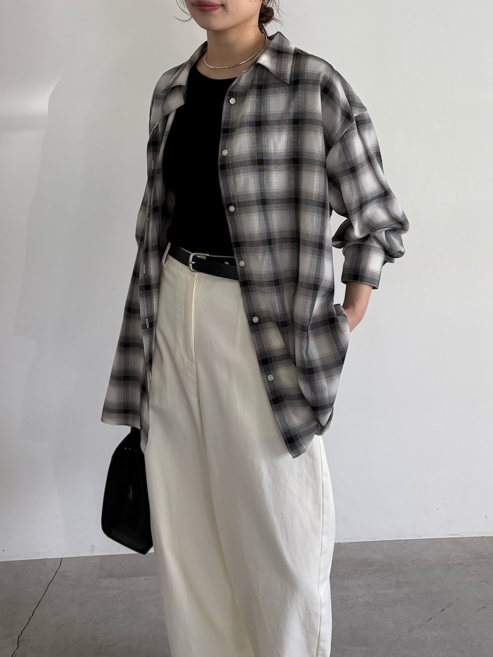 ブラック系のシャツ/ブラウス、ブラック系のボストンバッグ、ブラック系のスリッポンを着用したレディースの冬コーディネートの4枚目の写真