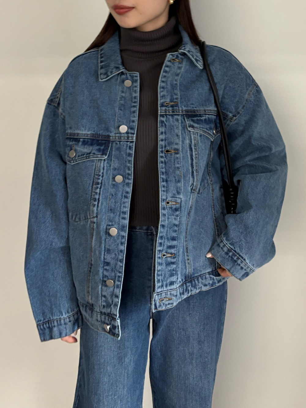 ブルー系のデニムジャケット、ブルー系のデニムパンツ、ブラック系のブーツを着用したレディースの冬コーディネートの4枚目の写真