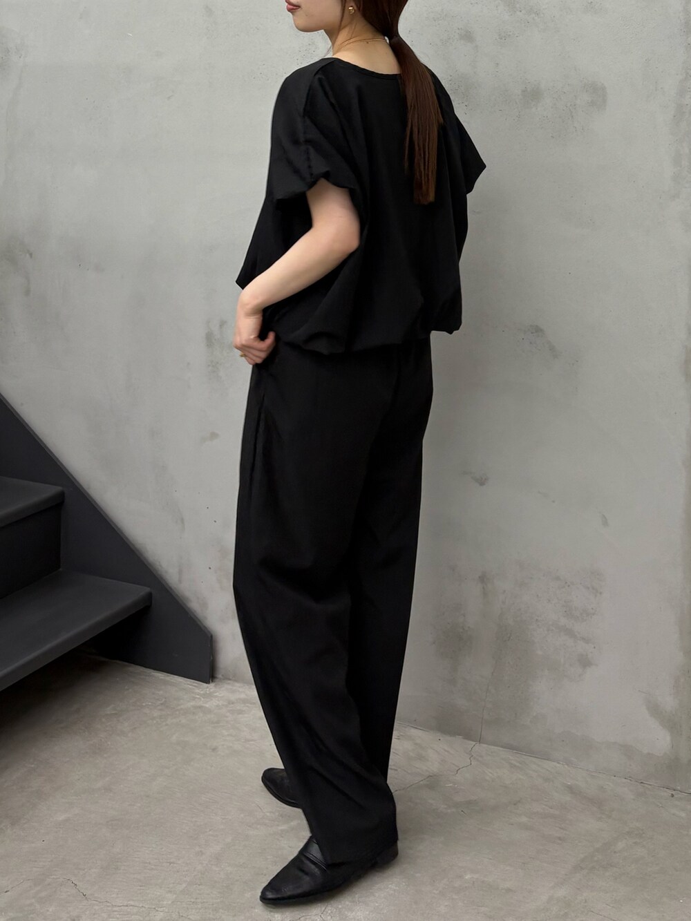 ブラック系のシャツ/ブラウス、ブラック系のその他パンツ、ゴールド系のネックレスを着用したレディースの春コーディネートの2枚目の写真