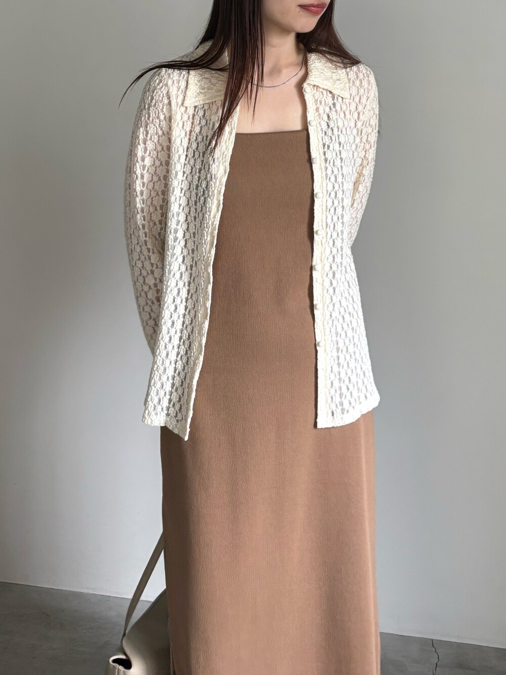 イエロー系のワンピース、ホワイト系のシャツ/ブラウス、ベージュ系のショルダーバッグを着用したレディースの春コーディネートの4枚目の写真