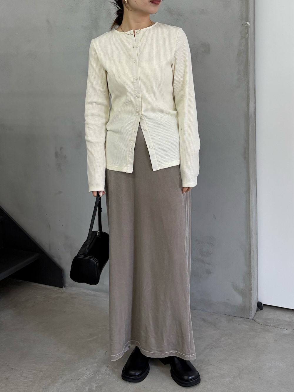 ホワイト系のTシャツ/カットソー、グレー系のスカート、ブラック系のスリッポンを着用したレディースの冬コーディネートの3枚目の写真